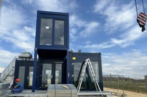 Der blaue Container-Komplex enthält im Bauteil rechts unten den Elektrolyseur, daneben entsteht das Wasserstofflabor - und oben thront das künftige Medienzentrum. Foto: H2-Wandel